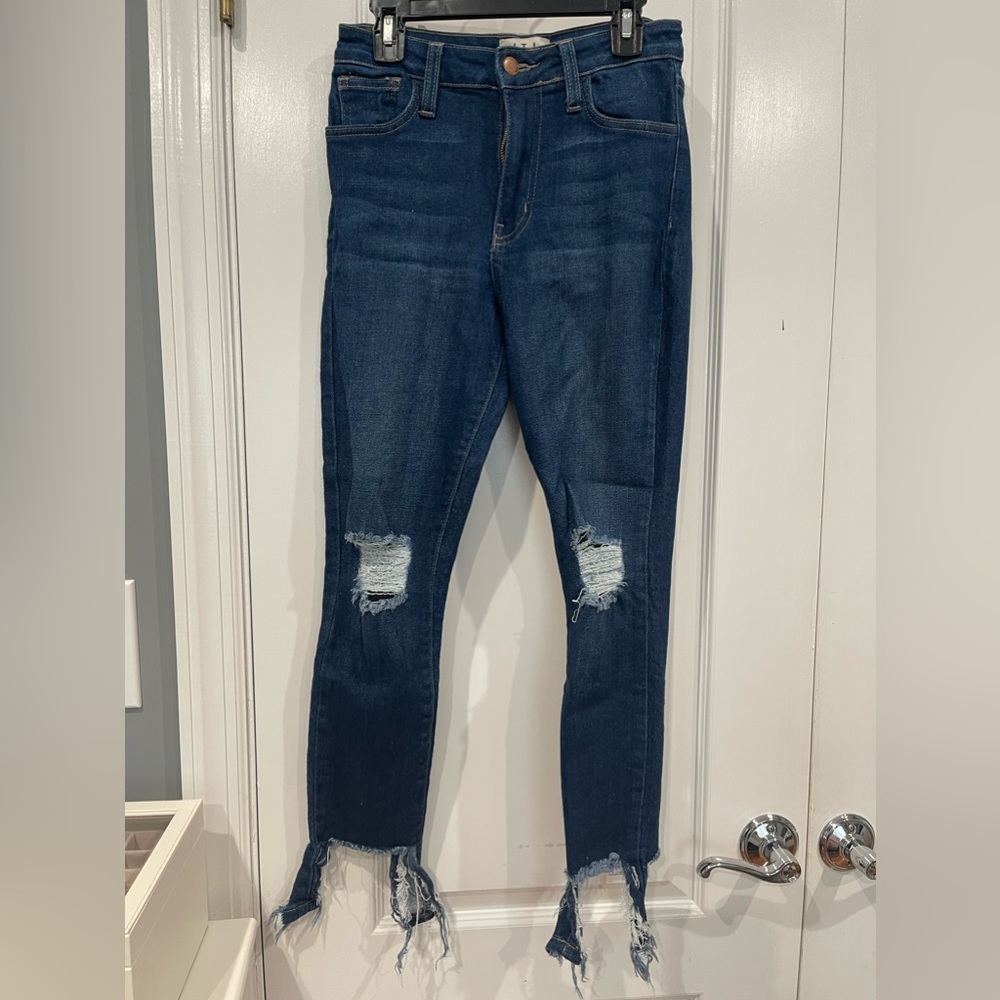 Dark wash skinny jeans with distressed knees and ankles